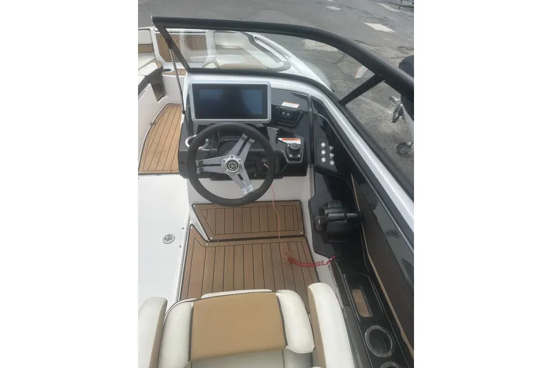 Slide: The Image of 2023 Yamaha Boats 252S cockpit with steering wheel, touchscreen, and wood accents. - 32