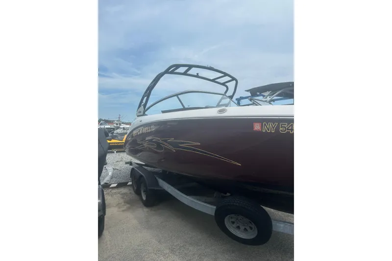 Slide: The Image of 2023 Yamaha Boats 252S on trailer, sleek design, parked outdoors under clear sky. - 3