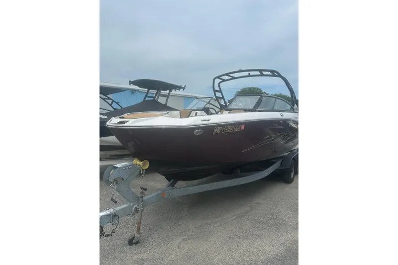 The Image of 2023 Yamaha Boats 252S on trailer, sleek design, parked outdoors. - 1
