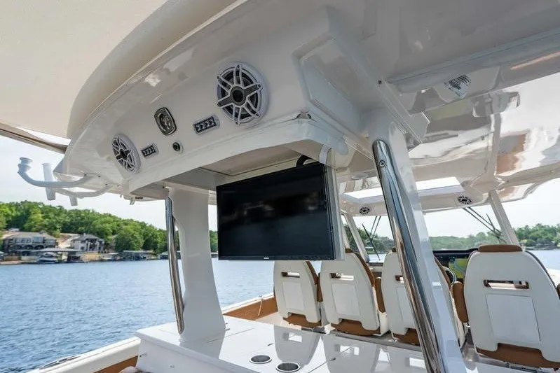 Slide: The Image of 2026 Regal 38 Surf boat interior with speakers and TV, overlooking a serene lake. - 13