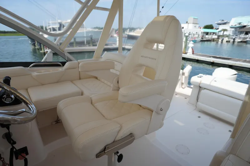 Slide: The Image of Luxurious seating on a 2018 Grady-White Express 330 boat, docked by the water. - 25