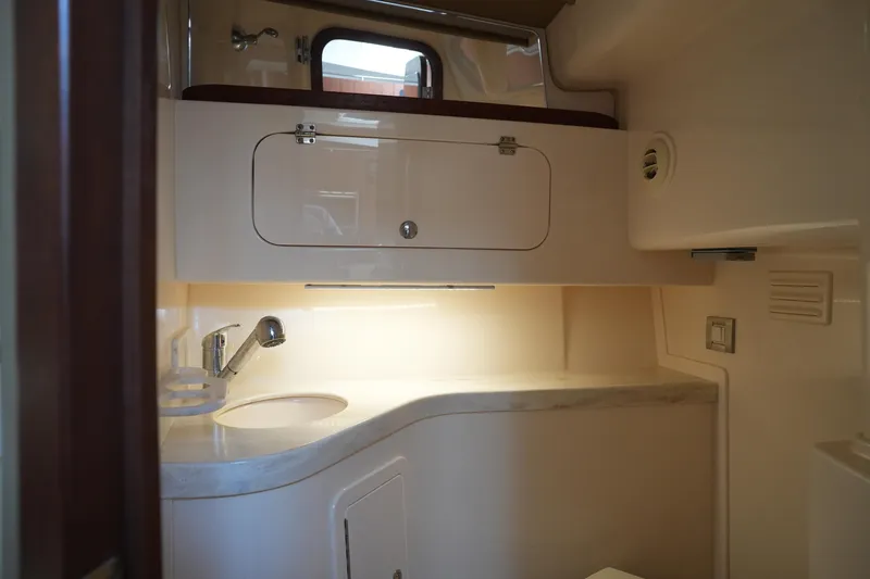 Slide: The Image of 2018 Grady-White Express 330 boat interior bathroom with sink and storage cabinet. - 31