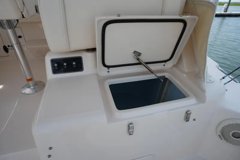 Slide: The Image of Open storage compartment on 2018 Grady-White Express 330 boat, featuring control panel and speaker. - 17