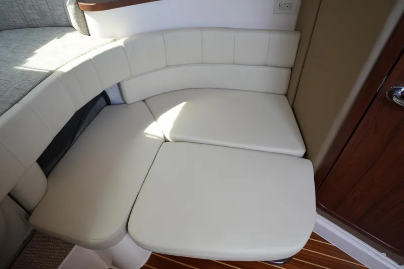 Slide: The Image of 2018 Grady-White Express 330 interior with white cushioned seating and wooden flooring. - 29