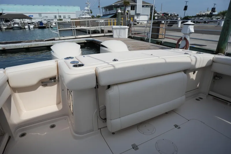 Slide: The Image of 2018 Grady-White Express 330 boat interior with cushioned seating at a marina dock. - 13