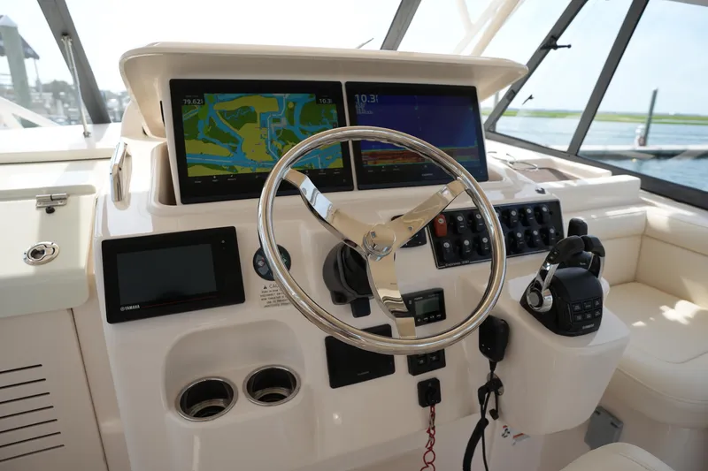 Slide: The Image of 2018 Grady-White Express 330 helm with navigation screens and steering wheel. - 22
