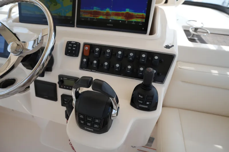 Slide: The Image of Control panel of 2018 Grady-White Express 330 boat with Yamaha controls and navigation screens. - 26