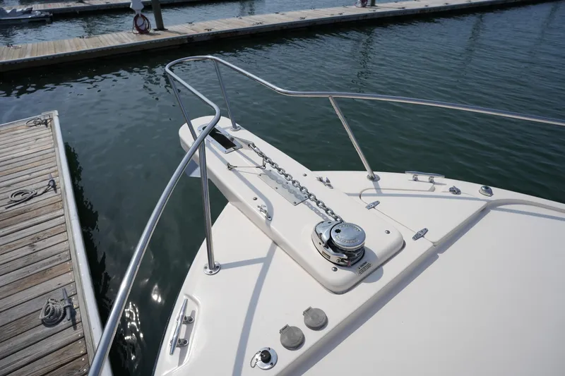 Slide: The Image of Bow of 2018 Grady-White Express 330 at dock, featuring anchor chain and railing. - 39
