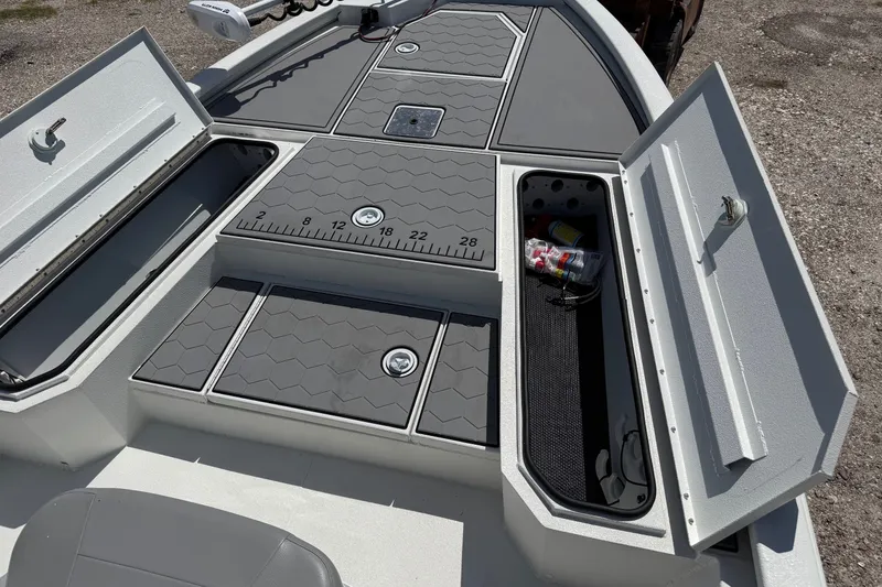 Slide: The Image of 2022 Avid 21 FST boat deck with open storage compartments and measuring ruler. - 13