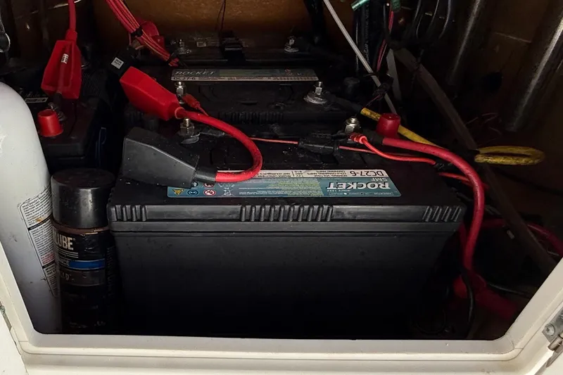 Slide: The Image of Battery compartment of Avid 21 FST 2022 model with cables and maintenance supplies. - 18