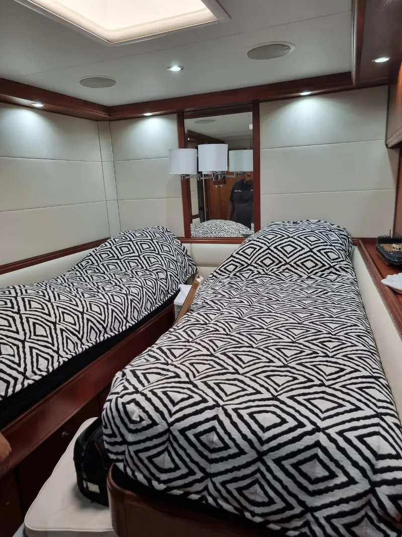 Slide: The Image of 2008 Bertram 670 Convertible yacht interior with twin beds and geometric bedding. - 30