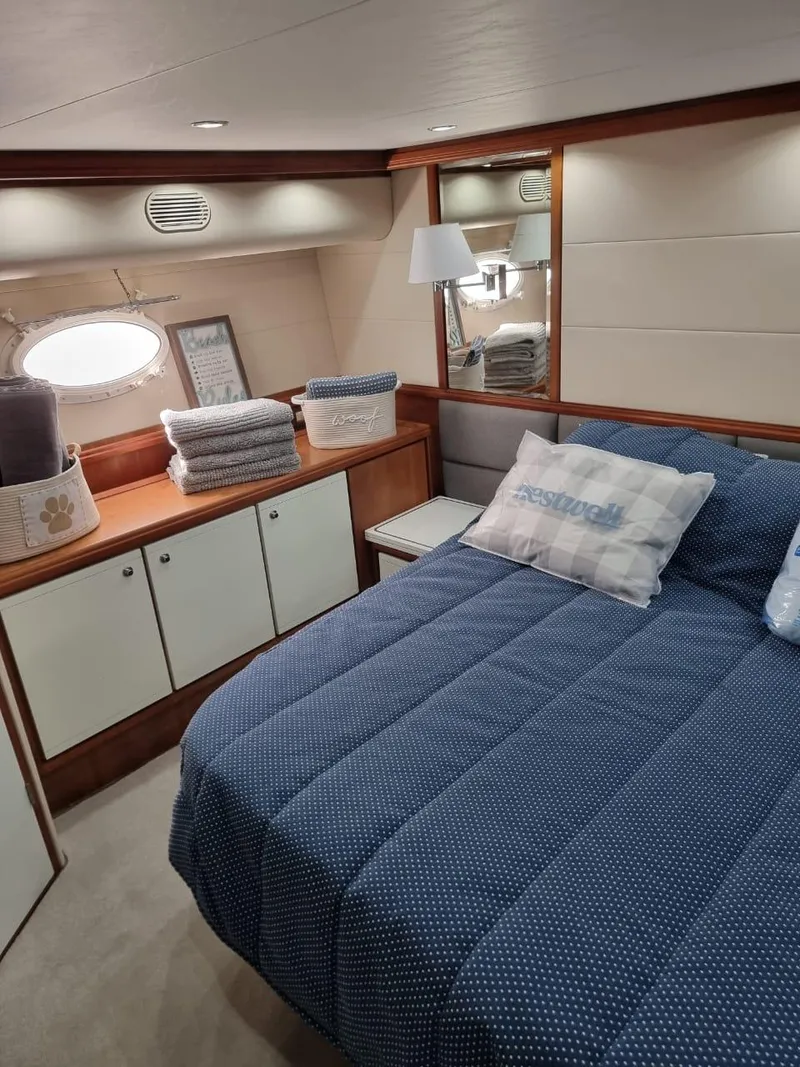 Slide: The Image of Luxurious bedroom interior of 2008 Bertram 670 Convertible yacht with blue bedding. - 25