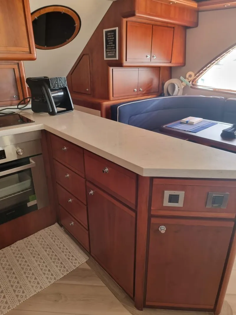 Slide: The Image of Interior of a 2008 Bertram 670 Convertible yacht with wooden cabinetry and modern appliances. - 18