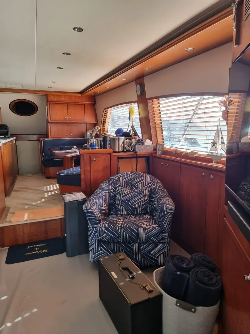 Slide: The Image of Interior of a 2008 Bertram 670 Convertible yacht with wooden furnishings and seating. - 21