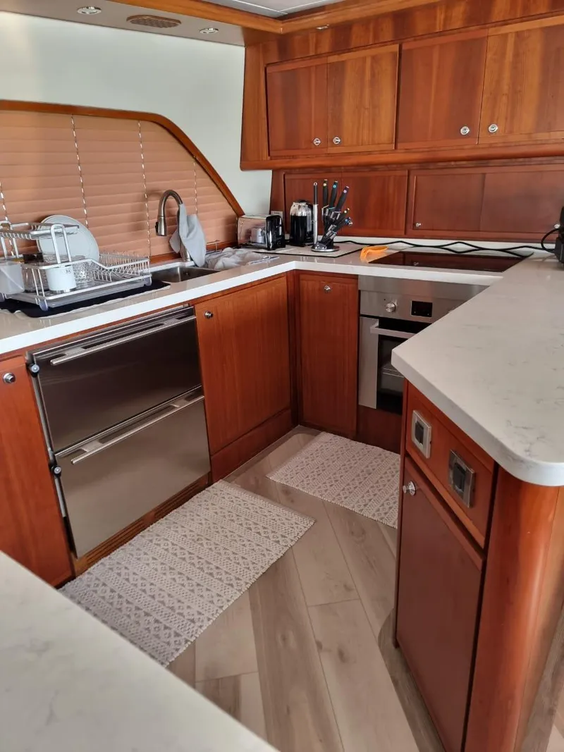 Slide: The Image of Modern kitchen in a 2008 Bertram 670 Convertible yacht with wooden cabinetry. - 15