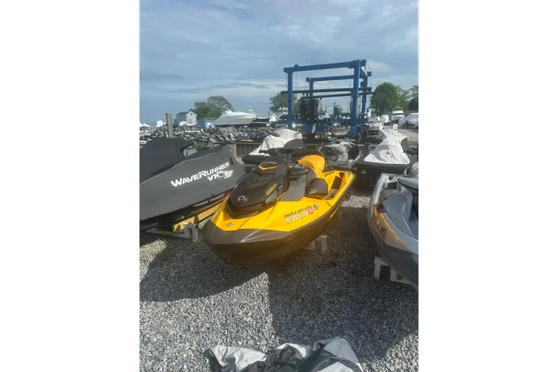 Slide: The Image of 2022 Sea-Doo GTR 230 jet ski in a marina, parked on gravel. - 2
