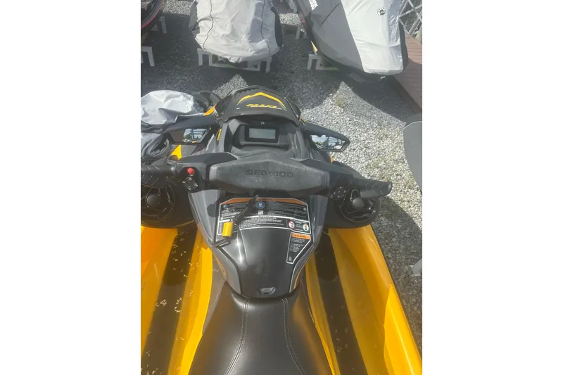 Slide: The Image of 2022 Sea-Doo GTR 230 jet ski, yellow and black, parked on gravel. - 10
