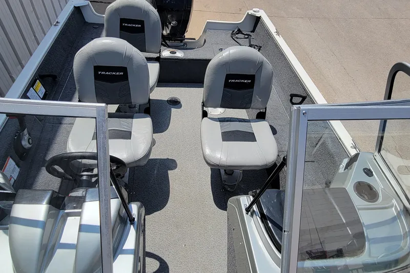 Slide: The Image of 2019 Tracker Pro Guide V-16 WT boat interior with two gray seats and steering console. - 17