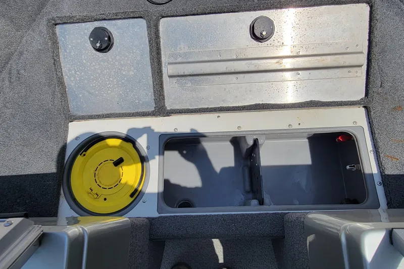 Slide: The Image of 2019 Tracker Pro Guide V-16 WT boat interior with storage compartments and yellow hatch. - 16