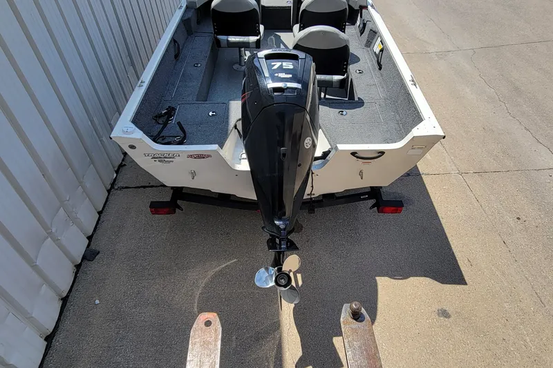 Slide: The Image of 2019 Tracker Pro Guide V-16 WT boat with Mercury 75 engine, parked on concrete. - 20