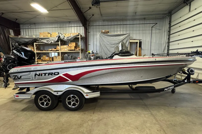 The Image of 2015 Nitro ZV21 boat in a garage, featuring sleek design and dual-axle trailer. - 0