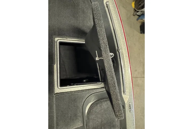 Slide: The Image of Open storage compartment in 2015 Nitro ZV21 boat, featuring carpeted interior and secure latch. - 21