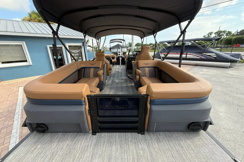 Slide: The Image of 2027 Bennington 24 M Quad Bench pontoon boat with spacious seating and elegant design. - 18