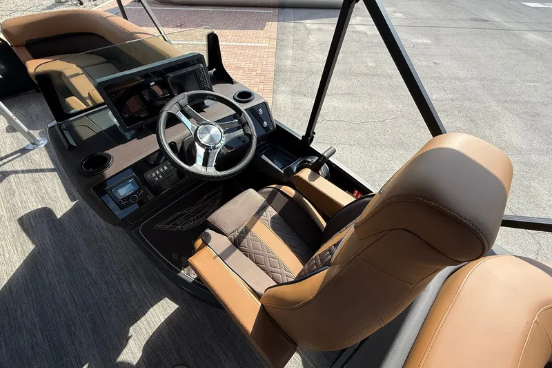 Slide: The Image of 2027 Bennington 24 M Quad Bench boat interior with steering wheel and luxurious seating. - 14