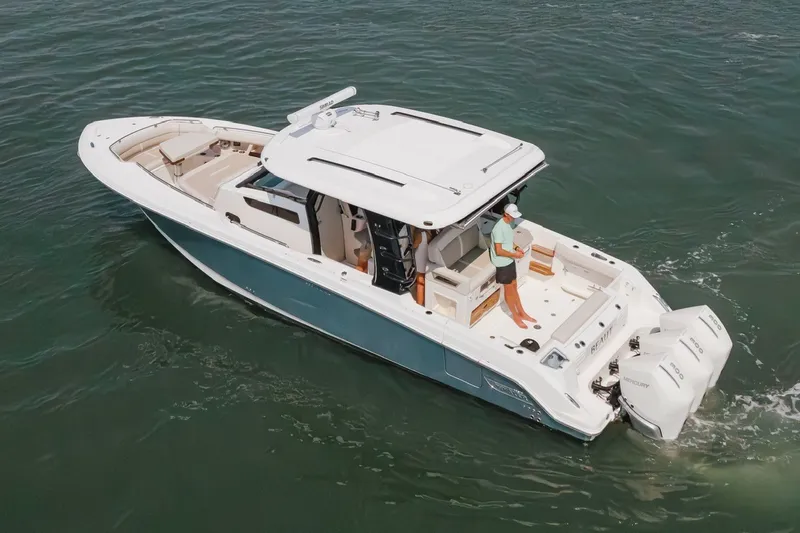 Slide: The Image of 2023 Boston Whaler 350 Realm boat cruising on open water with person onboard. - 4
