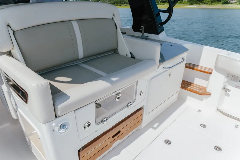 Slide: The Image of 2023 Boston Whaler 350 Realm boat interior with cushioned seating and storage compartments. - 13