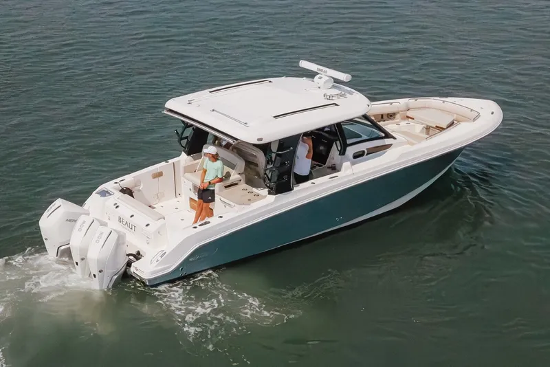 Slide: The Image of 2023 Boston Whaler 350 Realm cruising on water, featuring dual outboard engines. - 5