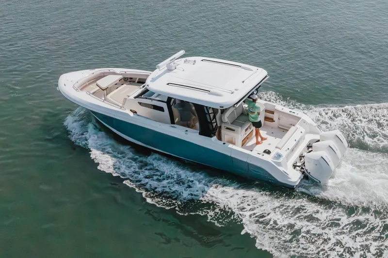 Slide: The Image of 2023 Boston Whaler 350 Realm cruising on open water, showcasing sleek design and powerful engines. - 21