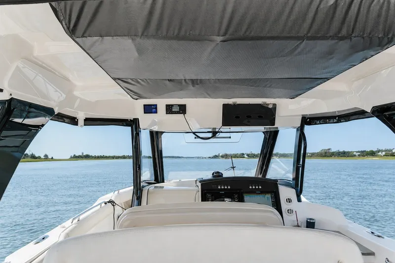 Slide: The Image of Interior view of 2023 Boston Whaler 350 Realm boat cockpit on open water. - 12