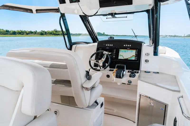 Slide: The Image of 2023 Boston Whaler 350 Realm helm with advanced navigation displays on open water. - 10
