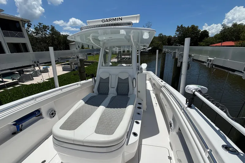Slide: The Image of 2024 Invincible 33 Catamaran with Garmin equipment, docked by a waterfront property. - 20