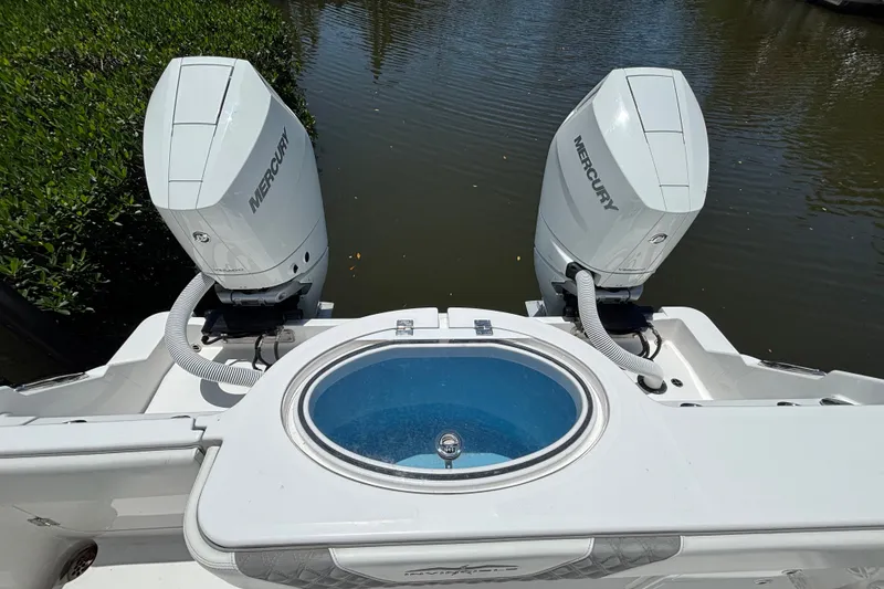 Slide: The Image of 2024 Invincible 33 Catamaran with dual Mercury outboard engines and livewell, docked on calm water. - 50