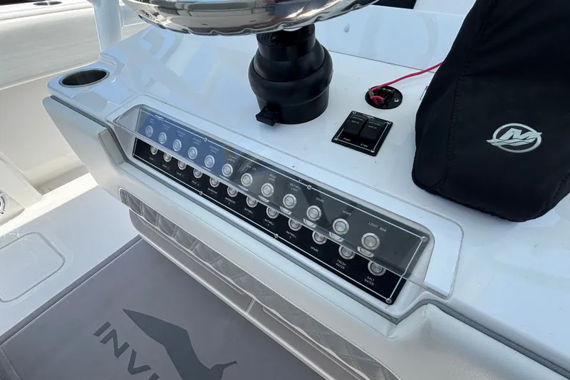 Slide: The Image of Control panel of 2024 Invincible 33 Catamaran with switches and cup holder. - 32