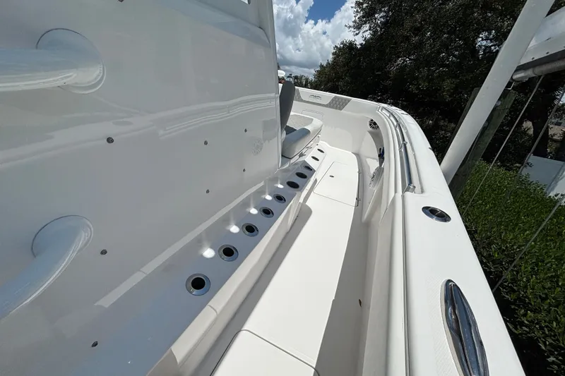 Slide: The Image of 2024 Invincible 33 Catamaran interior with sleek white design and rod holders. - 24