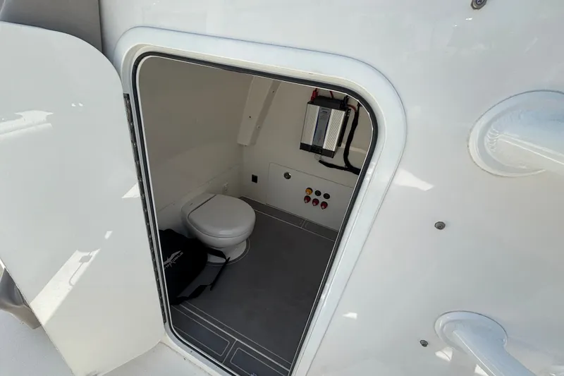 Slide: The Image of 2024 Invincible 33 Catamaran interior with compact marine toilet and control panel. - 55