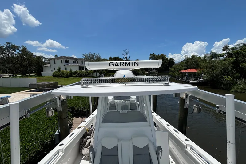Slide: The Image of 2024 Invincible 33 Catamaran with Garmin radar, docked by a scenic waterfront. - 13