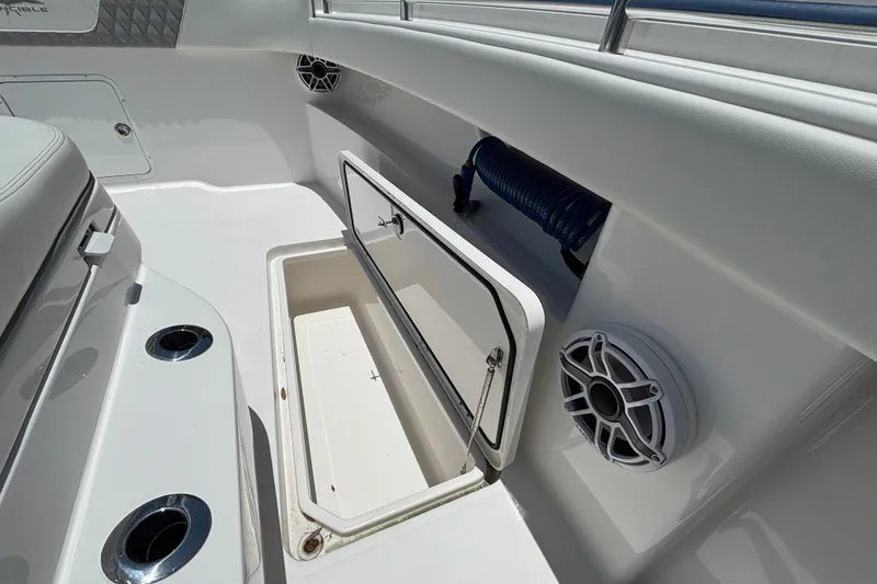 Slide: The Image of 2024 Invincible 33 Catamaran interior with open storage compartment and speaker. - 26