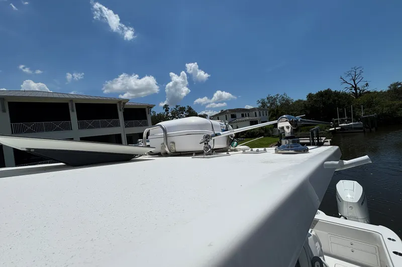 Slide: The Image of 2024 Invincible 33 Catamaran rooftop with radar and antennas, docked near waterfront homes. - 11