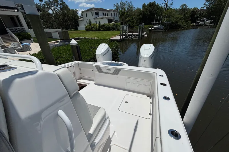 Slide: The Image of 2024 Invincible 33 Catamaran docked by waterfront home, showcasing sleek design and dual engines. - 7