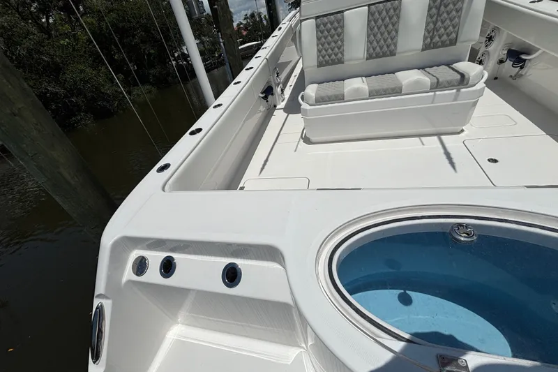 Slide: The Image of 2024 Invincible 33 Catamaran interior with seating and livewell, docked by water. - 47
