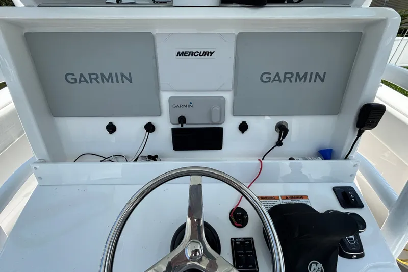 Slide: The Image of Helm of 2024 Invincible 33 Catamaran featuring dual Garmin displays and Mercury controls. - 31