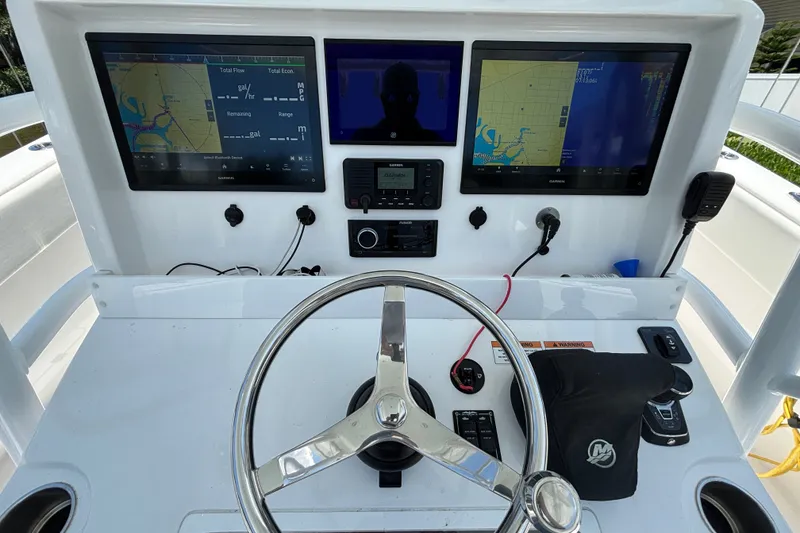 Slide: The Image of 2024 Invincible 33 Catamaran helm with dual Garmin displays and steering wheel. - 27