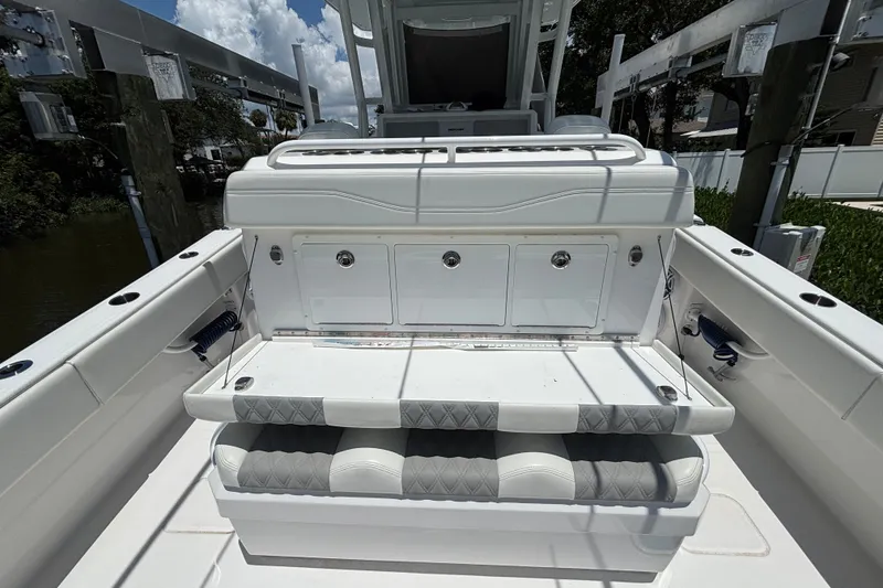 Slide: The Image of 2024 Invincible 33 Catamaran interior with cushioned seating and storage compartments. - 39