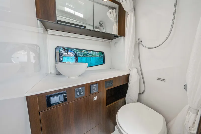 Slide: The Image of The image shows a modern yacht bathroom with wooden cabinets, a sink, and a window. - 47