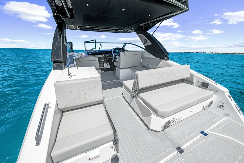 Slide: The Image of The image shows the spacious aft deck of a 2027 Cruisers Yachts 34 GLS OB on calm waters. - 24