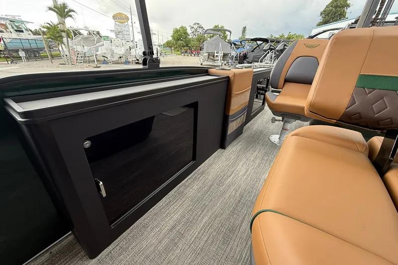 Slide: The Image of 2027 Bennington 24 M Fish and Cruise interior with tan seating and storage compartment. - 17